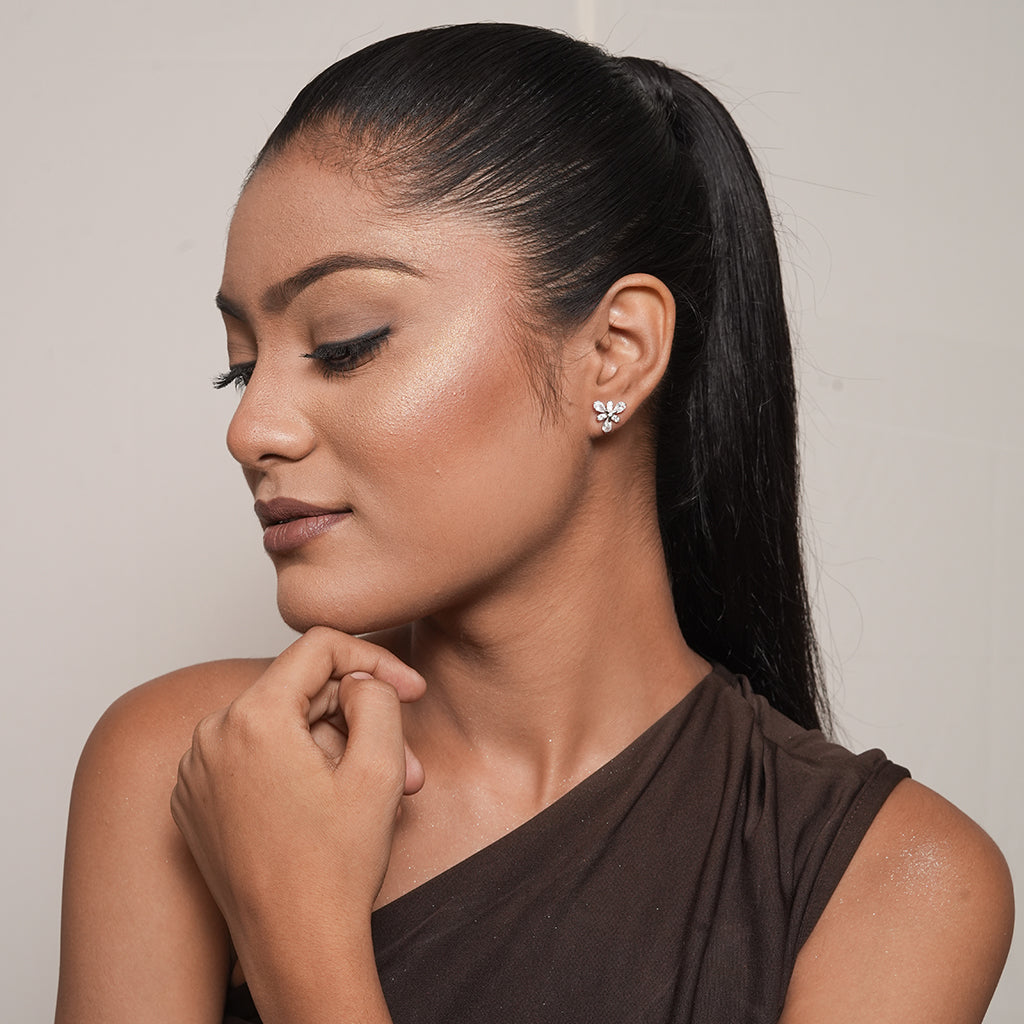 Model wearing Silver Pear CZ Flower Stud Earrings with a sparkling six-petal floral design