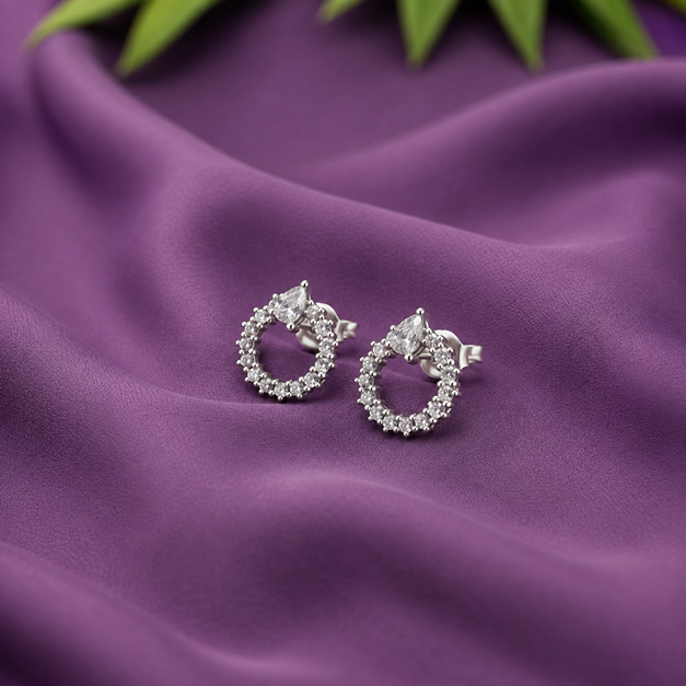 Pair of Silver Pear CZ Open Circle Stud Earrings displayed on purple fabric, showing the pear CZ tops and open round circles