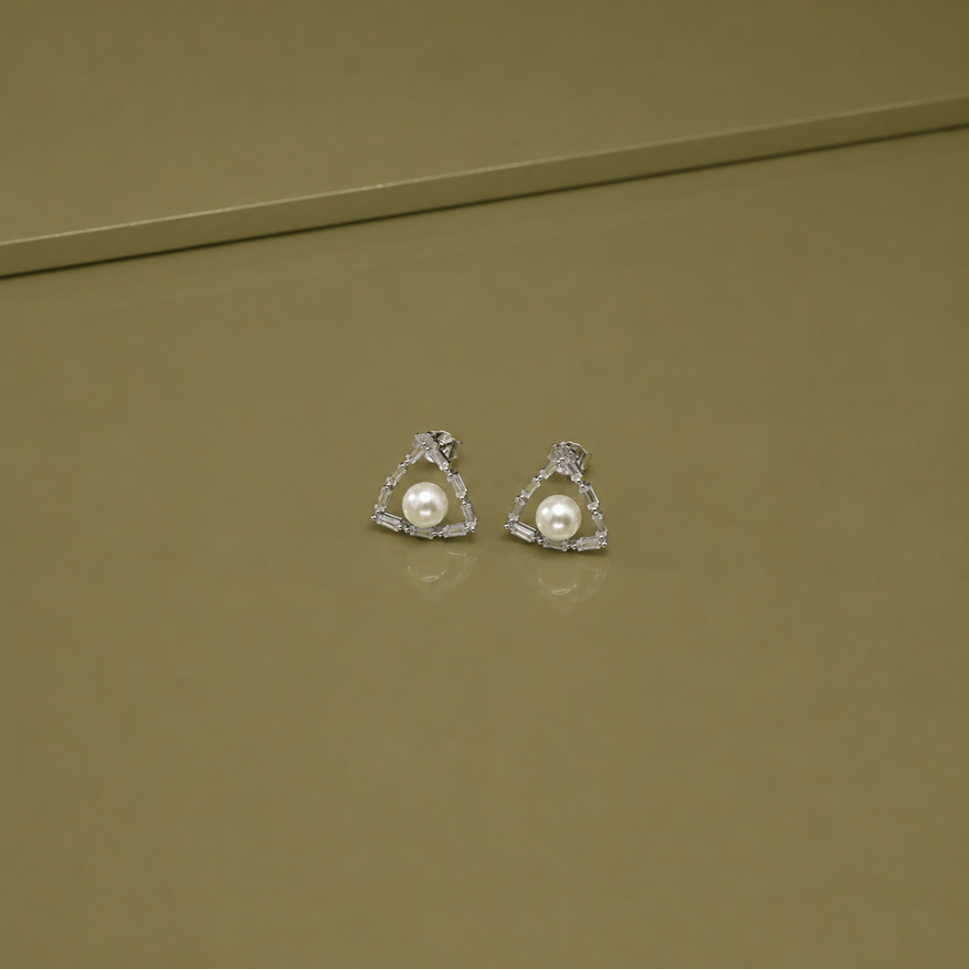 Pair of Silver Pearl Baguette Triangle Stud Earrings displayed on an olive surface with pearl centres and baguette-set triangular frames