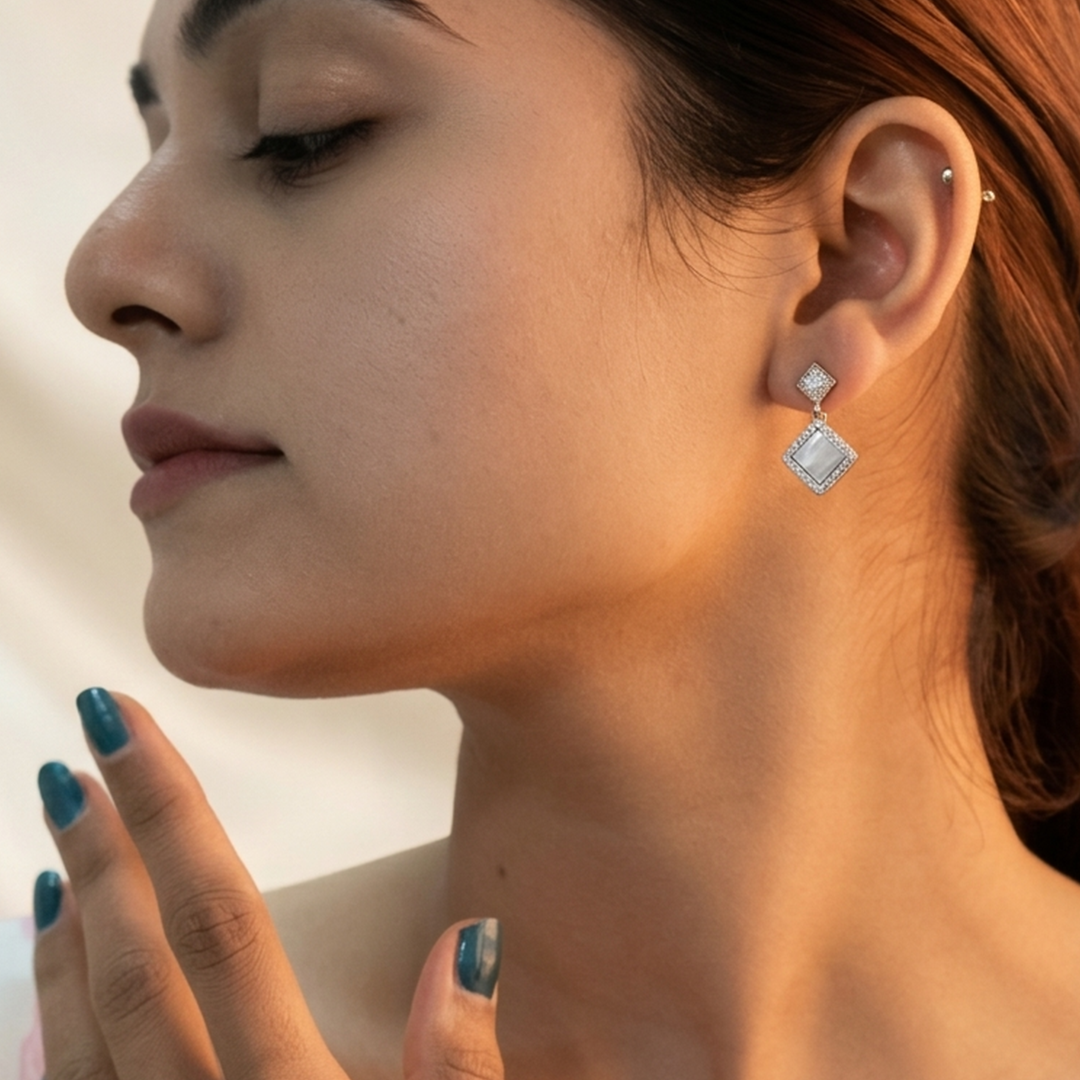 Close-up of a woman's face highlighting the sparkle and secure fit of the Silver Rhombus Mother of Pearl Earring.