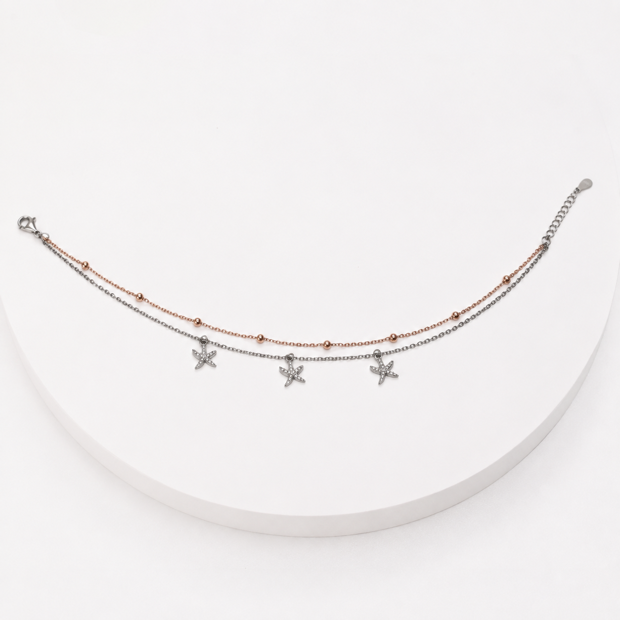 Layered anklet with rose gold starfish charms in silver