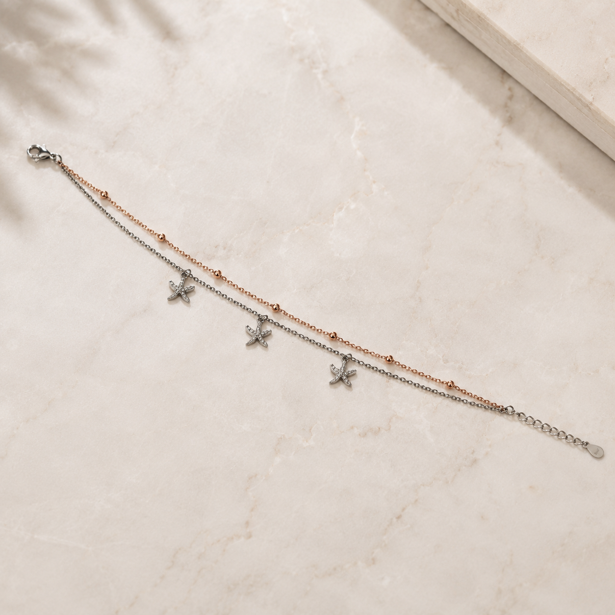 Pave starfish charms on an adjustable silver anklet