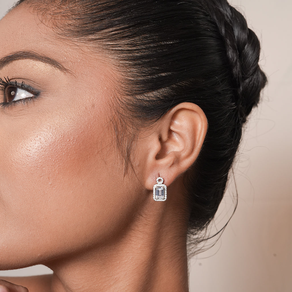 Close-up of Silver Round Halo Emerald Cut Drop Earrings showing a round halo stud above an emerald-cut centre stone with a sparkling rectangular halo
