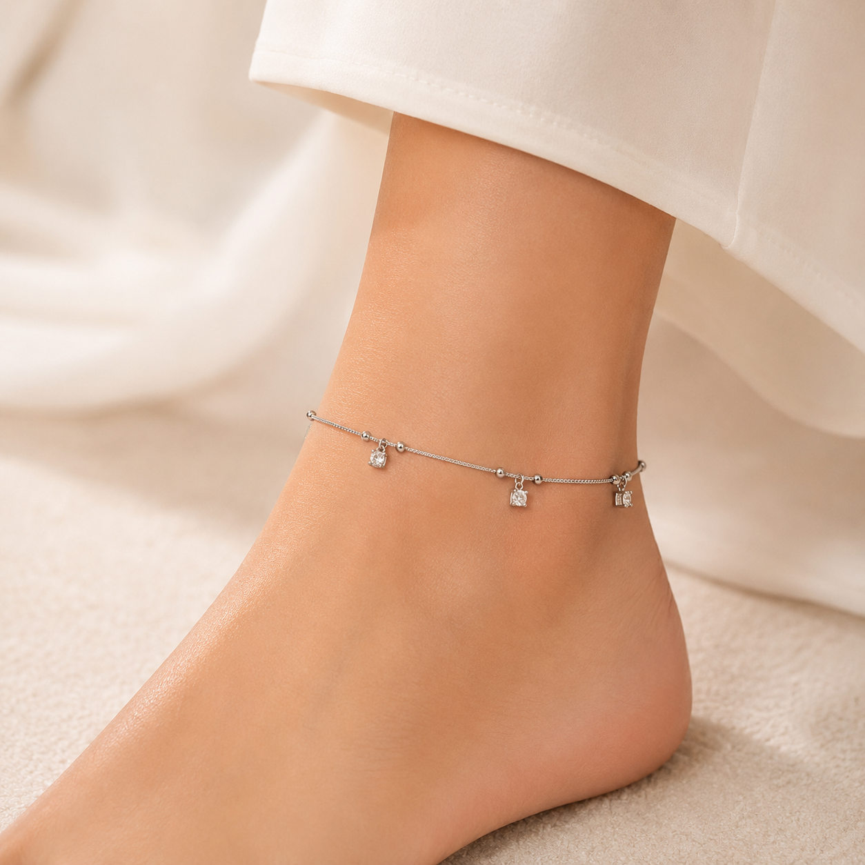 Row of square stone charms on a silver anklet