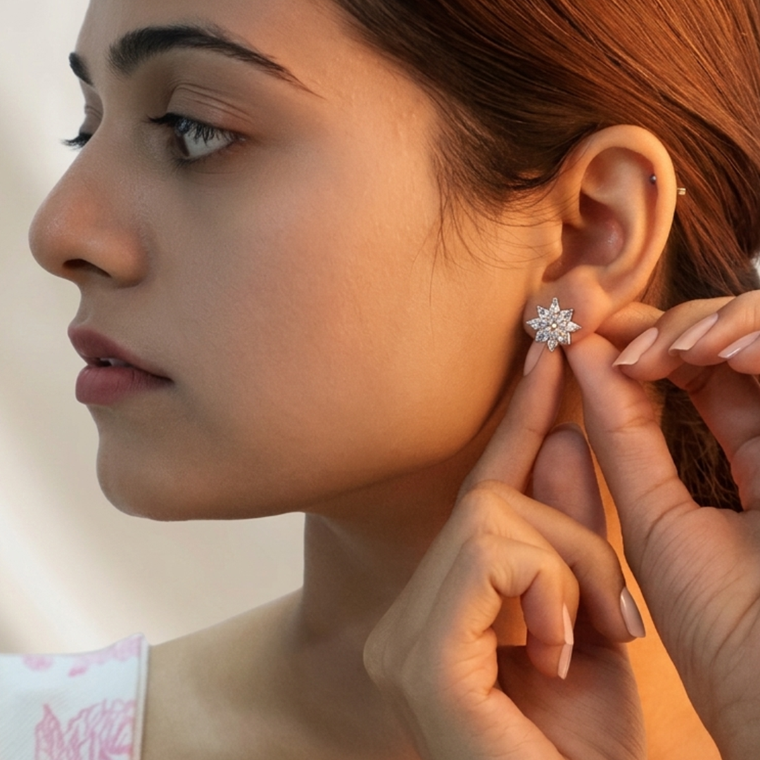 Woman gently adjusting the silver starburst stud earring on her earlobe