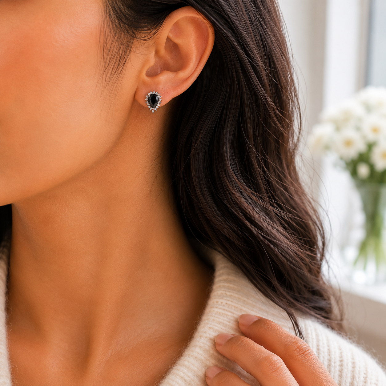 Side profile of a woman wearing the Teardrop Black Stone Halo Silver Stud Earrings, showing its elegant fit and scale on the earlobe.