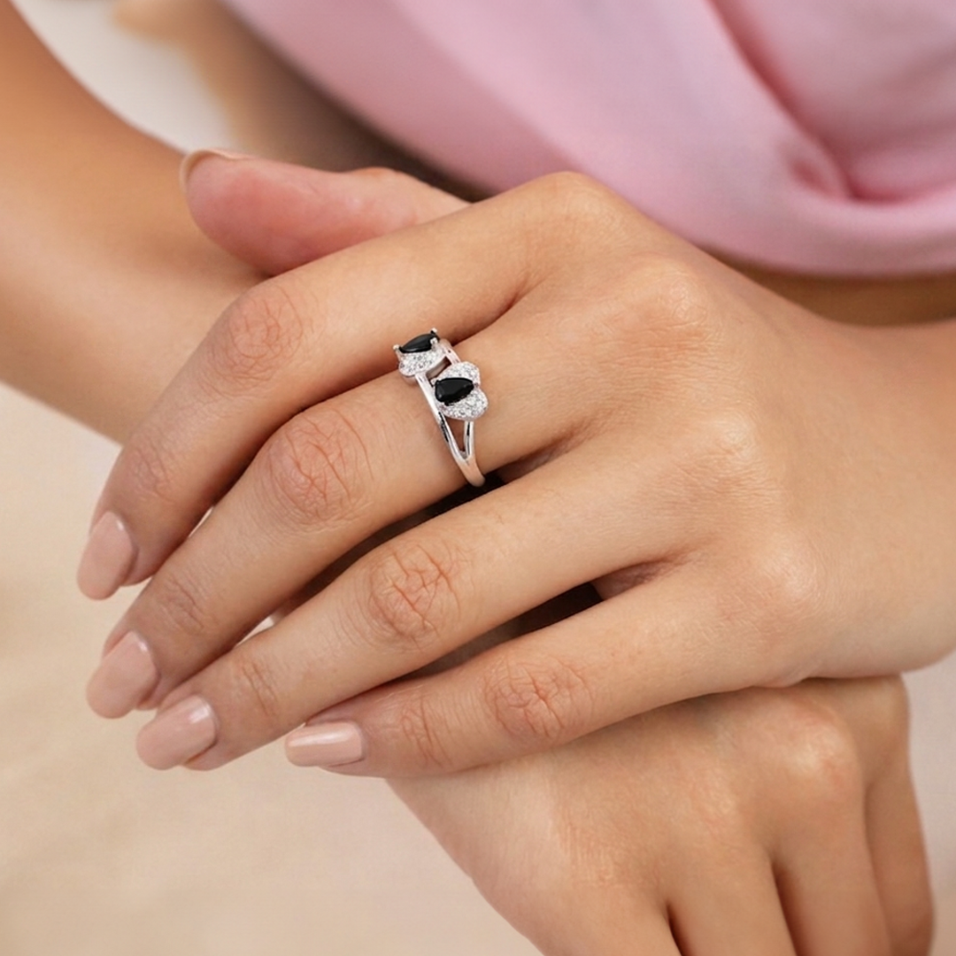 Close-up of the Twin Teardrop Black Stone Adjustable Silver Ring with two black pear-shaped stones worn on a finger