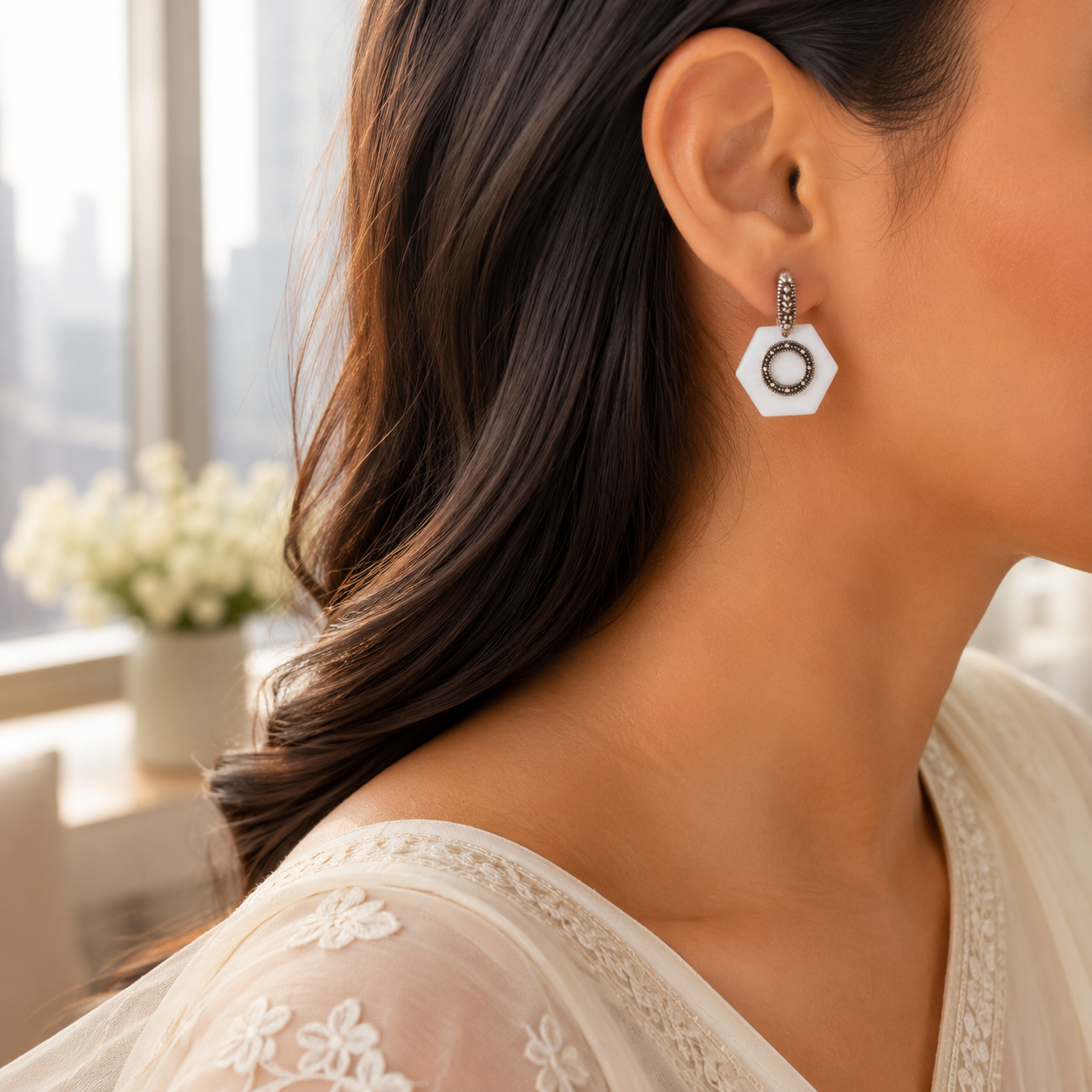 A woman modeling the White Hexagon Oxidized Silver Statement Earrings paired with a sheer white ethnic outfit.